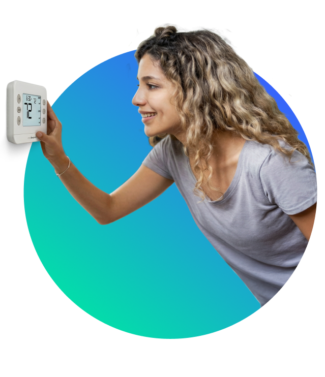 smiling woman checking the temperature on  her smart thermostat